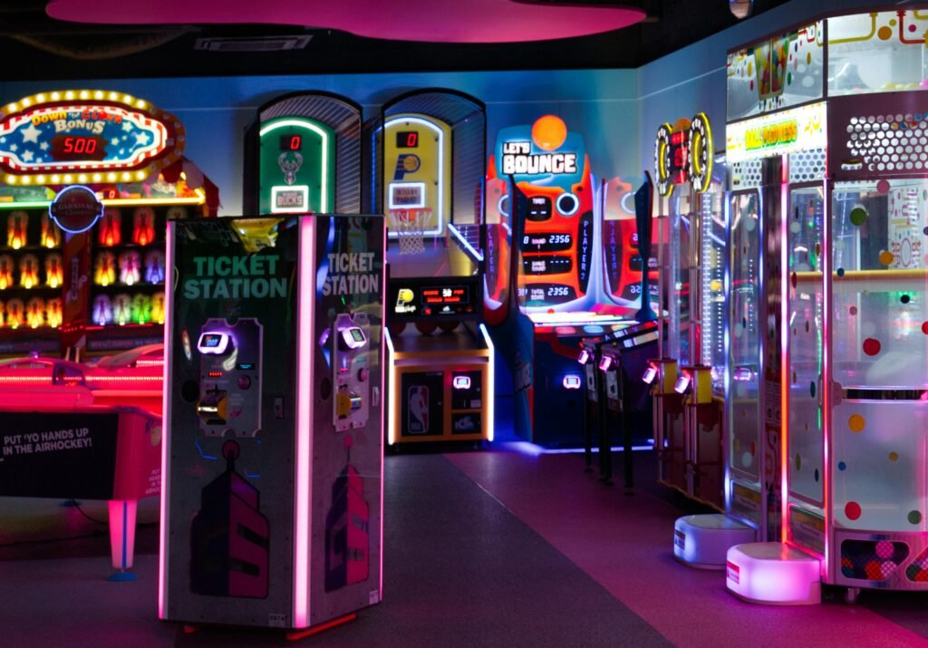Brightly lit arcade games and ticket stations in a vibrant indoor entertainment center.